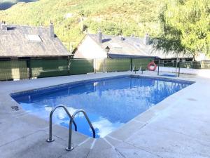a large swimming pool with blue water at Jarandín 27 - Adosado familiar en Biescas in Biescas