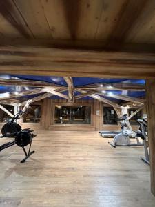 un gimnasio con techos de madera y máquinas de ejercicio en Appartement ski aux pieds dans résidence premium piscine, sauna hamam en Les Menuires