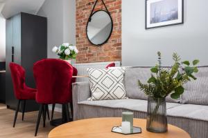 a living room with a couch and red chairs at Felicjanek 15 - by Upstairs in Kraków