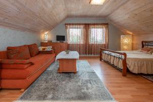 sala de estar con sofá y cama en Vila Terra Resort, en Girsteitiškis
