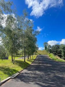 an empty road with trees on either side of it at Contemporary Townhouse Stunning lakeside location in Belturbet