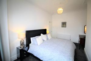 a bedroom with a large white bed with white pillows at Large Period Property - Beautifully Refurbished in Newcastle upon Tyne
