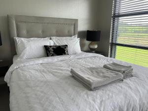 a white bed with two towels on top of it at Contemporary Townhouse Stunning lakeside location in Belturbet