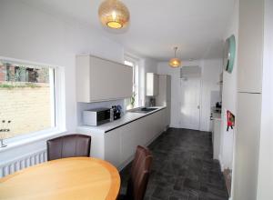 eine Küche mit einem Holztisch und einem Esszimmer in der Unterkunft Large Period Property - Beautifully Refurbished in Newcastle upon Tyne