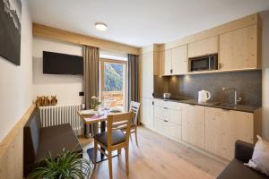 a kitchen and dining room with a table in a room at Ciasa Col Cuch in La Villa