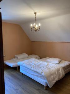 Murat-le-QuaireにあるMaison Le Pré Grandのシャンデリア付きの部屋のベッド2台