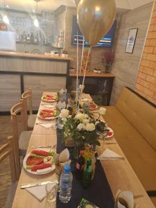 a long table with plates of food and a balloon at Къща за гости Марчела и Ресторант Мъри 