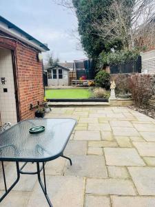 un patio con una mesa y un patio de ladrillo en 3bedroom beautiful cottage en Cheshunt