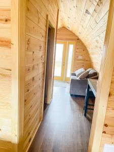 a hallway of a wooden cabin with a couch and a table at Hillside Cottages in Bay Roberts