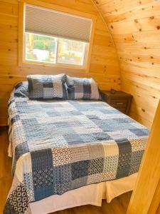 a bedroom with a bed in a wooden cabin at Hillside Cottages in Bay Roberts