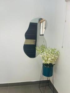 a mirror and a vase with flowers in a room at PH Apartment, Wuye in Abuja