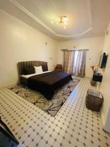 a bedroom with a bed and a tiled floor at PH Apartment, Wuye in Abuja