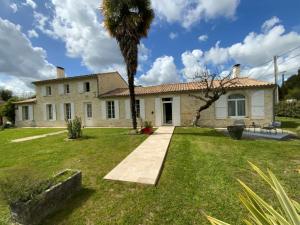 una casa con una palma nel cortile di L’océan 20 a Queyrac