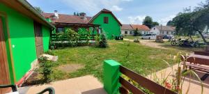 a green house with a yard with a bench at apartmán v areálu Hospoda u Dračice in Suchdol nad Lužnicí