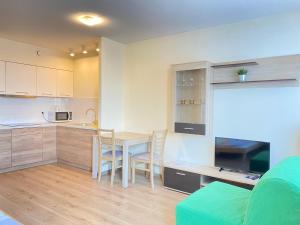 a kitchen and living room with a table and chairs at Residence Aparthotel in Szczecin