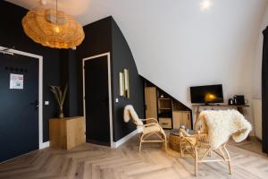 - un salon avec deux chaises et un escalier dans l'établissement Hotel Neptunus, à Egmond aan Zee