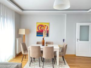 uma sala de jantar com uma mesa branca e cadeiras em NEW BUILDING Lovely Modern Apt with 90mbs fiber internet 5min walking to Bagdat Street em Istambul
