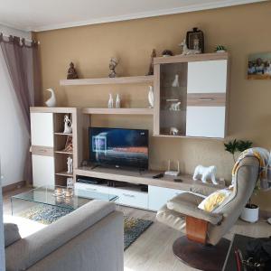 a living room with a couch and a tv at Casa Millie in Playa Flamenca