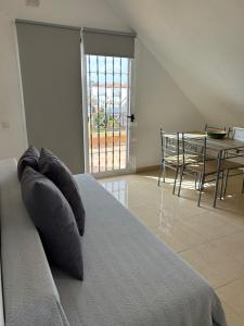a bedroom with a bed and a table with chairs at Caleta alto in Caleta De Fuste