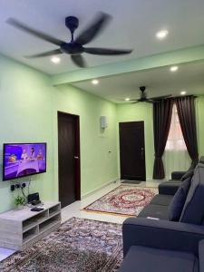a living room with a couch and a ceiling fan at Sri Aman Homestay in Jitra