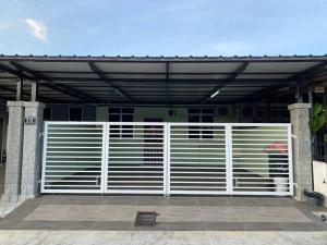 a white gate in front of a building at Sri Aman Homestay in Jitra