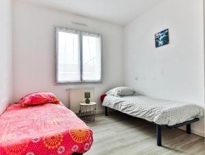 a bedroom with a bed and a bed and a window at Au Logis de la Treille in La Barre-de-Monts