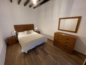 een slaapkamer met een bed met een spiegel en een dressoir bij Casa Jurel in Agüimes