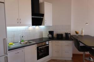 uma cozinha com armários brancos e um lavatório em Schönes Apartment mit Terrasse und Meerblick. em La Matanza de Acentejo