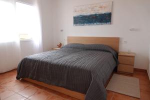 um quarto com uma cama com uma cabeceira de madeira em Schönes Apartment mit Terrasse und Meerblick. em La Matanza de Acentejo