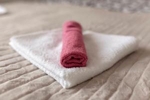 a red rolled up towel on a bed at Apartment Mountain Sunrise in Škofja Loka