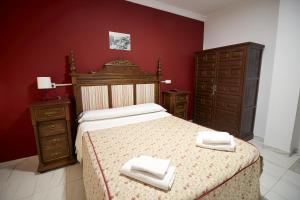 a bedroom with a bed with two towels on it at Hotel Virgen de los Reyes in Ronda