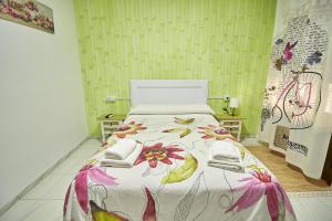 Hotel Virgen de los Reyes في روندا: غرفة نوم مع سرير مع لحاف متهالك