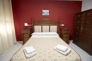 a bedroom with a bed with two white towels on it at Hotel Virgen de los Reyes in Ronda