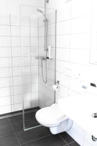 ein weißes Bad mit einem WC und einer Dusche in der Unterkunft Weingut - Gästezimmer Resch Ludwig vlg. Powoden in Leutschach