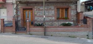 a brick house with a balcony with plants on it at A Casitta in Furnari