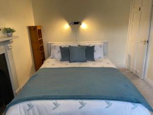 a bedroom with a large bed with blue pillows at Campion Cottage in Brixham