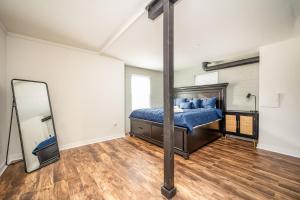 1 dormitorio con cama y espejo en Luxurious 4BR/3BA Stay in NW ATL en Atlanta
