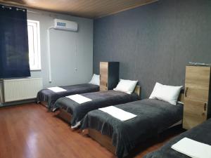 a room with three beds in a room at Мандри Хостел in Uzhhorod