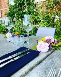 a table with two wine glasses and flowers on it at Tastecelebration Residence in Andrarum-Brosarp