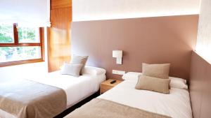 Habitación de hotel con 2 camas y ventana en Hotel Ocamiño, en Durango