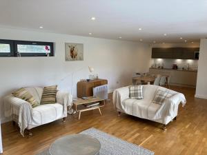 ein Wohnzimmer mit 2 weißen Sofas und einer Küche in der Unterkunft Independent rural detached annexe with free private Parking in Canterbury
