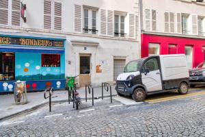 mały samochód zaparkowany na ulicy obok budynku w obiekcie Cozy apartement heart of Montmartre & historic Paris w Paryżu