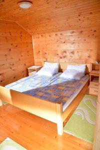a bed in a cabin with wooden walls at River house - Riječna idila in Cazin