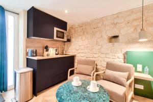 a small living room with a table and a kitchen at Magnifique studio au coeur de Montmartre in Paris