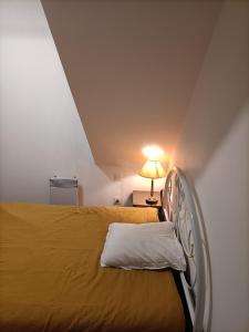 sypialnia z łóżkiem i lampką w pokoju w obiekcie La Dourbie w mieście Saint-Jean-du-Bruel