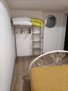 mały pokój z łóżkiem i półką z ręcznikami w obiekcie La Dourbie w mieście Saint-Jean-du-Bruel