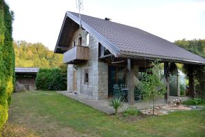 una pequeña casa de piedra con techo negro en River house - Riječna idila, en Cazin