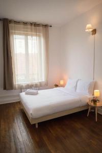 um quarto branco com uma cama e uma janela em A1G Nancy Thermal Artem chambre em Nancy