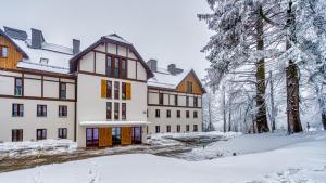a building in the snow with snow covered trees at Apartament A2 DOMiTU z Basenem, Sauną, Jacuzzi - 5D Apartments in Szklarska Poręba