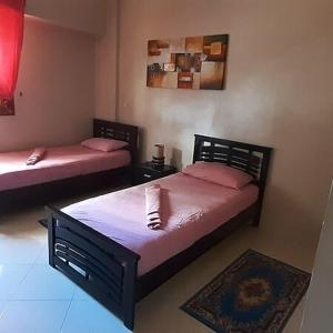 een slaapkamer met 2 bedden en een tapijt bij Dar Inn Raha 1 in Laayoune